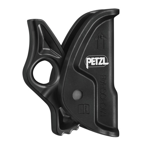 Imagen de un bloqueador de cambio Petzl Micrograb negro. El dispositivo presenta un diseño ergonómico con un lazo para la fijación y un mecanismo de palanca integrado para el ajuste de la empuñadura. Se muestra el logotipo de Petzl prominente, junto con una flecha que apunta hacia arriba.