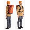Se ve a una persona con un suéter marrón, pantalones grises y un gorro naranja en dos poses, destacando la llamativa Mochila Sea To Summit Big River Dry Backpack 50L. Esta espaciosa mochila presenta colores rojo y naranja con correas negras y muestra de manera prominente el logotipo "Sea to Summit".