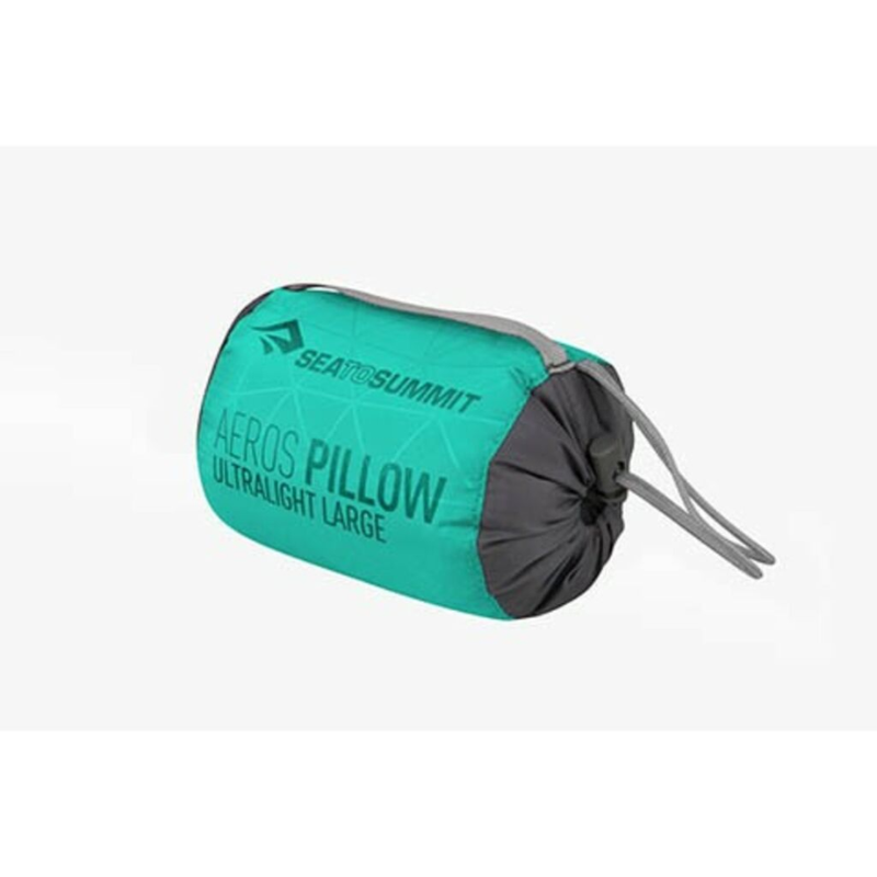 Almohada ultraliviana Sea to Summit Aeros compacta en verde azulado y gris, etiquetada como "ultraliviana grande", que viene en un paquete con cordón. Ideal para viajeros que buscan una almohada inflable cómoda y liviana.