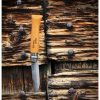 Un Cuchillo Opinel N°9 VRN de Acero Carbono con mango de madera yace abierto sobre una superficie rústica, su elegante hoja de metal brilla contra la madera texturizada con nudos y clavos visibles.