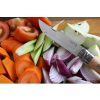 Un Cuchillo Opinel N°12 de Acero Inoxidable está elegantemente colocado entre una vibrante mezcla de tomates en rodajas, zanahorias, apio, manzanas y cebollas rojas en una tabla de cortar de madera.