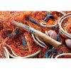 Descansando sobre una maraña de redes de pesca y cuerdas de color naranja se encuentra el Cuchillo Opinel N°9 de Acero Inoxidable, que presenta un mango de madera con la marca "Opinel" claramente visible en él.