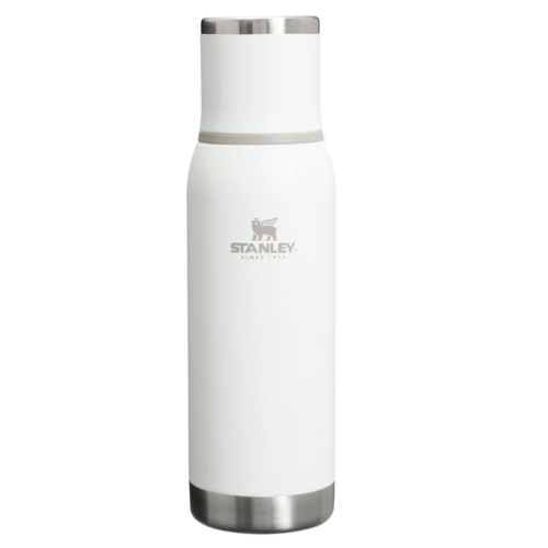Una botella de agua de acero inoxidable con aislamiento Termo Stanley de color blanco de 750 ml con tapa y base plateadas, que presenta el logotipo y texto de Stanley en gris en el frente, perfecta para tu próxima aventura para llevar.