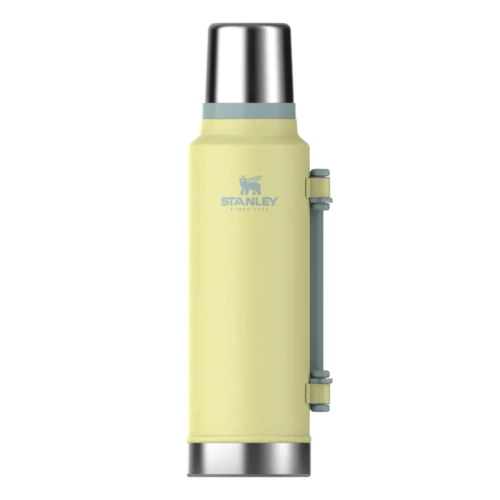 Un Termo Stanley Classic de 1,4 l de color amarillo con tapa y base de metal, un asa lateral gris y el logotipo y texto de la marca cerca de la parte superior.