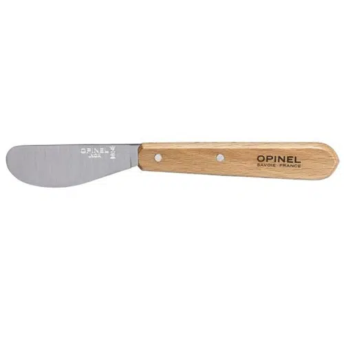 El Cuchillo Opinel N°117 Mantequilla cuenta con una hoja de acero inoxidable y un mango de madera de color marrón claro, marcado con "OPINEL SAVOIE-FRANCE" en letras negras. Su punta plana y redondeada es ideal para untar, lo que lo convierte en una herramienta de cocina indispensable.