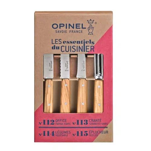Un juego de cuchillos de cocina Opinel en caja, conocido como Set de Cuchillos Opinel Les Essentiels Olivo 4pc. La caja contiene cuatro cuchillos con mangos de madera: un cuchillo para pelar, un cuchillo de sierra, un cuchillo para verduras y un pelador. El embalaje es de cartón marrón con texto azul y rojo y recortes que revelan los cuchillos en el interior.