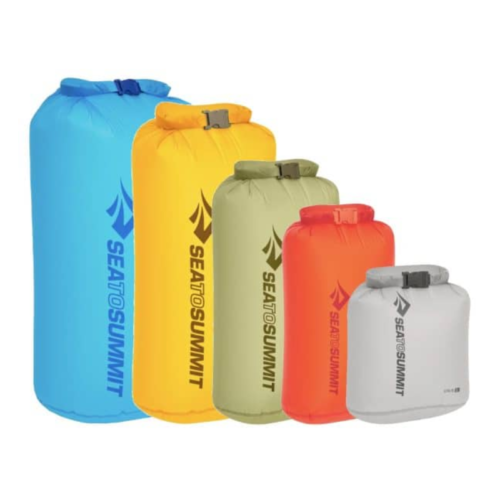 Se muestran cinco bolsas secas Bolsa Seca Sea To Summit Ultra-Sil en diferentes tamaños, disponibles en azul, amarillo, naranja, verde y gris. Cuentan con cierres enrollables y el logotipo de la marca en un lugar destacado en el frente.