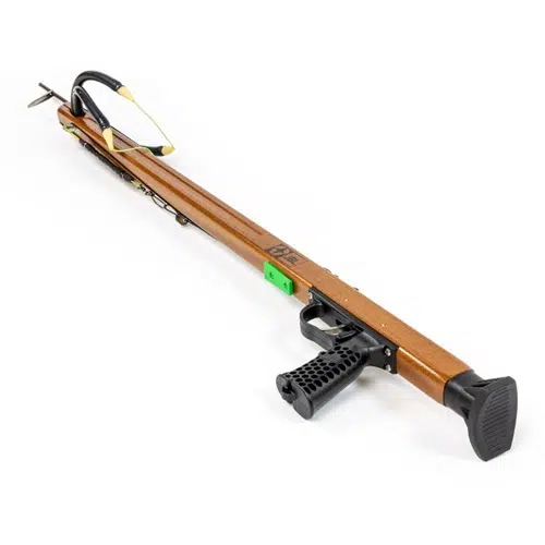 El fusil de pesca submarina Arpón Madera Woody Elite Custom de 29" de JBL cuenta con un cañón de madera de 29" junto con un elegante mango negro y un mecanismo de gatillo de precisión. Cuenta con una punta de lanza de metal firmemente sujeta, complementada con la característica lengüeta de seguridad verde y una correa de goma con muescas para facilitar la carga, lo que lo convierte en una excelente opción para los entusiastas de JBL.