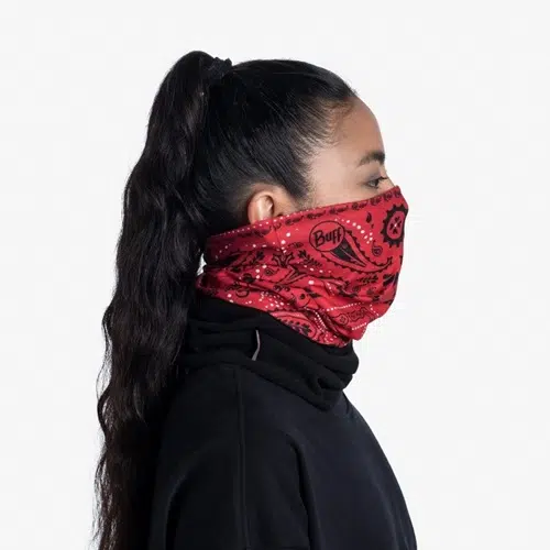 Una persona con el pelo largo recogido en una cola de caballo lleva una polaina de cuello EcoStretch estilo pañuelo rojo que le cubre la nariz y la boca, lo que le añade un toque de estilo a su look. Está vestida con una elegante camiseta negra sobre un fondo blanco liso.