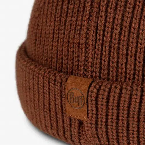 Primer plano del gorro Buff Tricot Ervin, que muestra su ala doblada, que cuenta con una pequeña etiqueta de tela que muestra la marca "Buff". La textura de punto visible le suma un atractivo acogedor.
