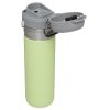 La Botella Térmica Stanley Quick Flip de 709 ml de color verde claro cuenta con un elegante cuerpo de acero inoxidable y una tapa abatible gris que revela el pico para beber, lo que hace que esta elegante taza de viaje sea ideal para disfrutar de bebidas frías o calientes de forma segura mientras viaja.