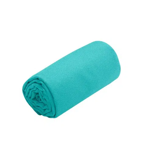 Sobre un fondo blanco liso se coloca una Toalla Sea To Summit Airlite de color turquesa brillante cuidadosamente enrollada. La toalla parece suave y está hecha de un material ligero y absorbente.