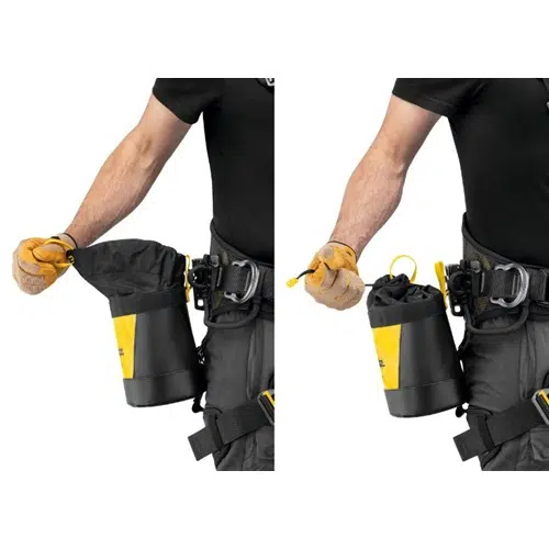 Una persona equipada con un arnés de seguridad y guantes amarillos exhibe la Bolsa Portaherramientas Petzl Toolbag 3, caracterizada por su diseño en negro y amarillo y cierre con cordón. La bolsa portaherramientas adaptable se presenta tanto en estado abierto como cerrado, firmemente sujeta al arnés.