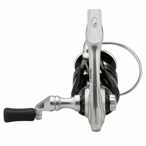Una vista de arriba hacia abajo muestra el Carrete Dam Quick 1 FD, un elegante carrete de pesca en plata y negro con un mango en el lado izquierdo. El nombre de la marca "Quick" se muestra de forma destacada, lo que refleja su diseño moderno ideal para cañas de pescar.