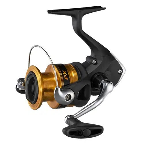 Un elegante carrete de pesca giratorio Shimano FX 1000FC de 170 m/0,18 mm con una bobina dorada, un cuerpo negro y una manivela metálica. El diseño incluye un brazo de agarre y una perilla para una recuperación eficiente de la línea, y la apariencia general es moderna y estilizada.