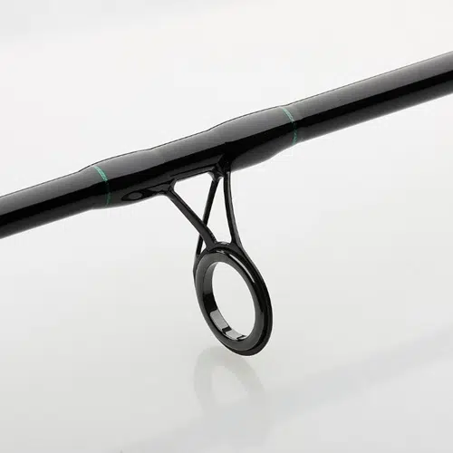 Primer plano de la Caña Dam Base X Spin que muestra su guía para caña de pescar, que presenta un elegante diseño negro con detalles verdes. La guía incluye un lazo circular de metal para dirigir la línea, todo sobre un fondo suave y claro.