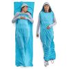 Dos mujeres llevan pijamas de color azul claro hechos con sacos de dormir. Una está acostada y la otra de pie, envueltas en el acogedor forro Sea To Summit Coolmax Breeze. Vestidas con camisetas de manga larga y gorros grises, parecen cómodas y relajadas.