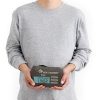 Una persona con una sudadera gris sostiene en sus manos un paquete rectangular de Liner Sea To Summit Comfort Blend.