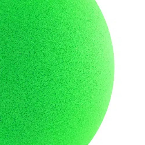 Primer plano de la superficie texturizada de color verde vibrante del Balón de Esponja Uk Time Sport 8″, que resalta su diseño intrincado y poroso. La foto se centra en una sección de este artículo esférico sobre un fondo blanco.