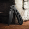 La Navaja Boker Magnum Shadow 01MB428 es una navaja plegable negra que presenta cortes circulares en el mango, que se muestra abierta sobre una superficie metálica desgastada. El logotipo de la hoja le suma un aspecto elegante y resistente, lo que la convierte en una herramienta muy solicitada por los entusiastas.