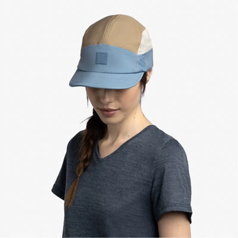 Mujer usando el Jockey Buff 5 Panel Go Domus color steel, mostrando el ajuste cómodo y el diseño multicolor de la gorra en acción