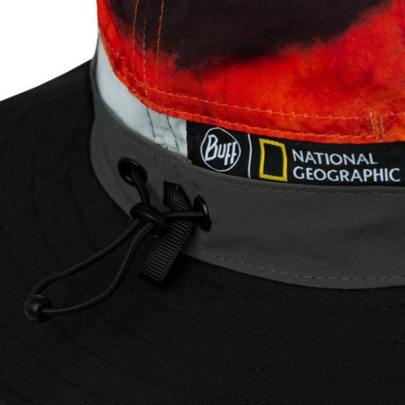 Primer plano del gorro Buff Explore Booney Harq Multi, que presenta un llamativo diseño en rojo y naranja. Cuenta con etiquetas cosidas de Buff y National Geographic y un cordón ajustable de color negro en el lateral.