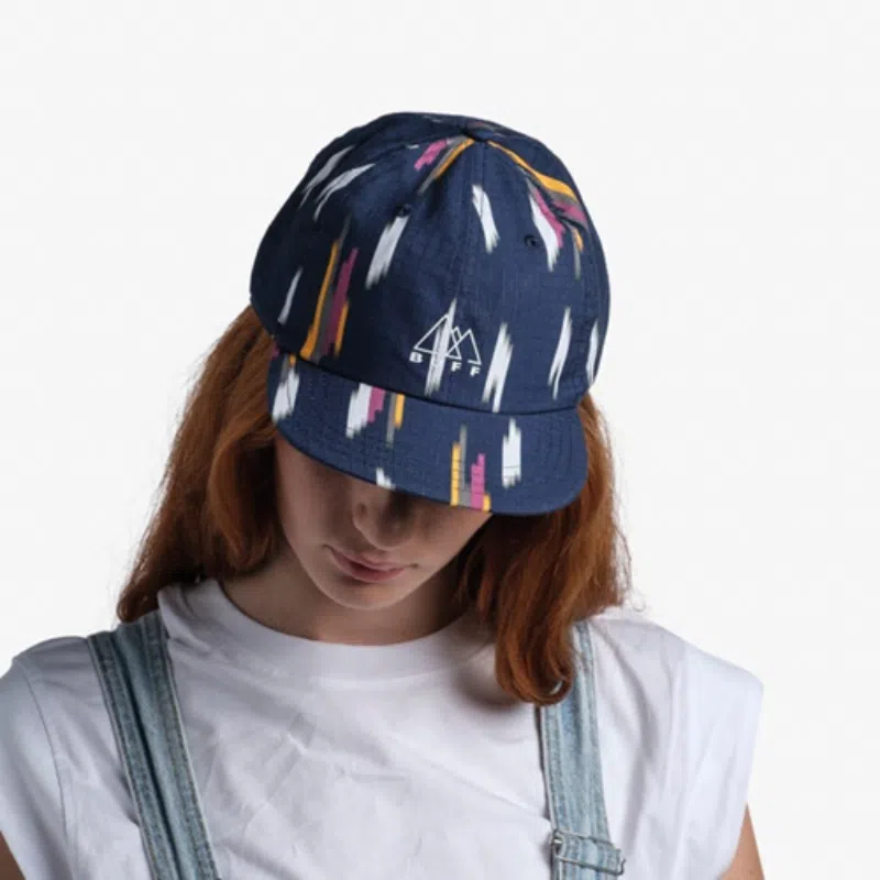 Mujer usando la gorra Jockey Buff Pack Baseball Elat Navy, mostrando el diseño colorido y casual del accesorio.