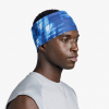 Una persona que viste una elegante diadema Cinta Buff CoolNet UV Wide Attel Blue y una camiseta sin mangas de color gris claro se encuentra sobre un fondo blanco liso y mira hacia un lado.
