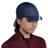 Mujer usando el Jockey Buff Pack Cycle Lenir en color Night Blue, una gorra ultraligera diseñada para ciclistas, ideal para usar bajo el casco y hecha con materiales reciclados.