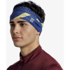 Una persona que lleva un casco interior Cinta Buff con estampado Akim Cobalt y una chaqueta con cremallera color granate sobre un fondo blanco liso.