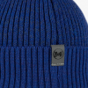 El Gorro Buff Merino Active Solid Cobalt se ejemplifica mediante una imagen en primer plano de un gorro de punto acanalado azul, que presenta una pequeña etiqueta gris con "Buff" en letras negras.