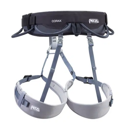 Imagen de un arnés de escalada Arnés Petzl Corax 2024. El Arnés Petzl Corax 2024 cuenta con un cinturón acolchado y perneras ajustables para mayor comodidad y seguridad. Es principalmente gris, con detalles en negro y varios portamateriales para sujetar el equipo de escalada. El logotipo de Petzl es visible.