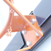 Primer plano de una estructura metálica de color naranja con tornillos y cables, posiblemente parte de un conjunto mecánico más grande, que se asemeja al diseño robusto de un Tablero Básquetbol Uk Time Sport S010 con Aro Junior. Se ven algunos paneles en blanco y negro en el fondo.