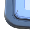 Primer plano de un marco rectangular, probablemente de metal o plástico, con una cubierta transparente asegurada por un tornillo en una esquina. La superficie brillante refleja la luz como el brillo de una ventana o cubierta protectora.