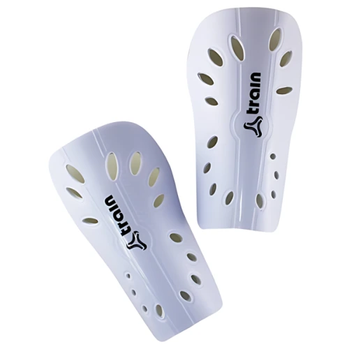 Un par de espinilleras blancas Canillera Train Training, con múltiples orificios de ventilación de forma ovalada y la marca "Train" impresa en negro verticalmente a lo largo de cada protección. El diseño elegante ofrece protección y flujo de aire, lo que las hace ideales para sesiones de entrenamiento.