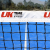 Primer plano de una red de tenis en una cancha azul, con la inscripción "Red Paddle UK Time Sport 10 m x 0,92 m" impresa en la cinta de la red. Los árboles y un cielo despejado complementan el sereno telón de fondo.