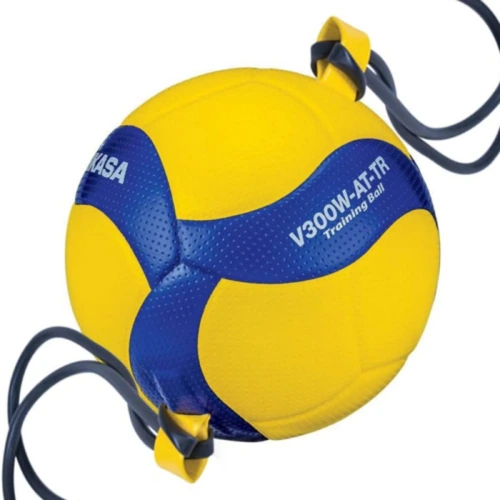 Un balón de voleibol de color amarillo y azul, etiquetado "Balón Voleibol MIKASA V300W-AT-TR" y "MIKASA", está asegurado con correas elásticas negras.