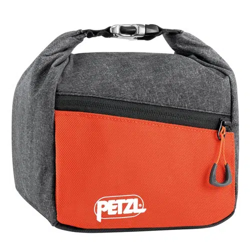 La bolsa para magnesio Petzl Sakab, compacta y duradera, está diseñada con una parte superior plegable con cremallera. La sección superior es gris, mientras que la sección inferior es naranja y presenta el logotipo "PETZL" en blanco. Un clip negro en la parte superior garantiza un cierre seguro.