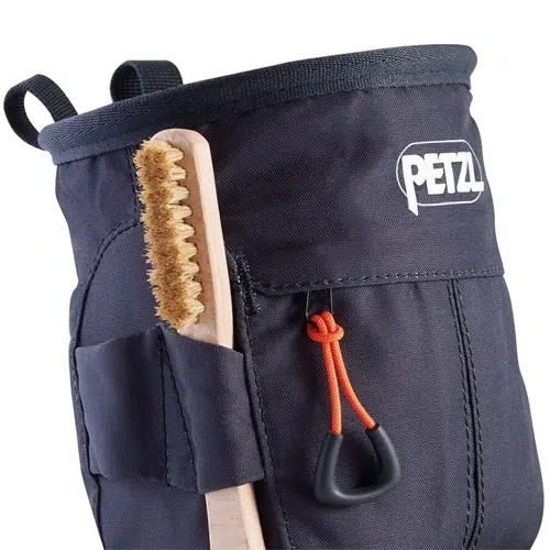 Primer plano de la bolsa para magnesio Sakapoche de Bolsa Petzl para Magnesio que muestra su diseño de tela oscura. Viene con un lazo para un cepillo de madera, un cierre con cordón naranja y una lengüeta negra para tirar, lo que la hace ideal para llevar magnesio para escalada.