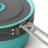 Primer plano de una olla plegable Sea To Summit Frontier 1.3L en color verde azulado y gris, resaltando su mango de metal unido al costado, sobre un fondo blanco.