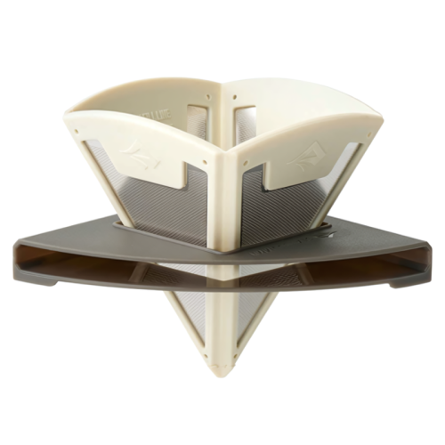 Fotografía en primer plano de un objeto geométrico y abstracto fabricado con materiales plásticos en blanco y gris. El diseño presenta paneles triangulares entrecruzados con superficies texturizadas y ranuras, montados sobre una base plana de color marrón oscuro. La estructura tiene una apariencia moderna y elegante que recuerda a la serie Vertidor Plegable Sea To Summit Ultralight Frontier.