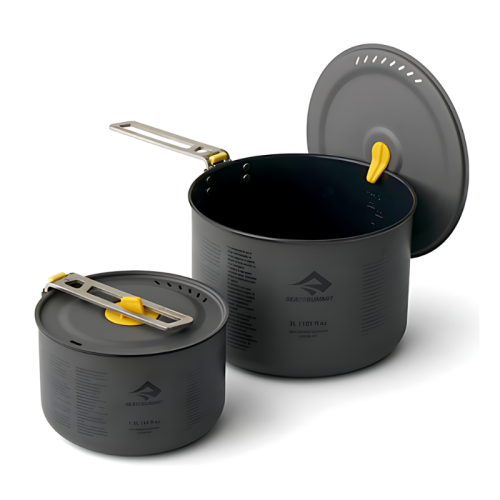 Se muestra un juego de dos ollas para cocinar Sea To Summit Frontier de color gris oscuro con asas amarillas plegables y tapas extraíbles, una más pequeña y otra más grande. Ambas ollas tienen marcas de medición en los costados y un logotipo que dice "SEA TO SUMMIT". La tapa de la olla más grande está ligeramente entreabierta. Este juego de ollas Sea To Summit Frontier de 2 piezas es perfecto para aventuras al aire libre.