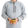 Una persona con un suéter de polar gris sostiene con ambas manos una Taza Plegable Sea To Summit Frontier 400ml de color amarillo vibrante y negro sobre un fondo blanco.