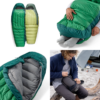 Las imágenes muestran el saco de dormir Pluma Sea to Summit Ascent verde y amarillo; una persona se relaja en su interior, mientras que otra lo comprime para que sea más portátil. Su acogedor interior gris enfatiza la calidez y un diseño bien pensado, ideal para aventuras de campamento.