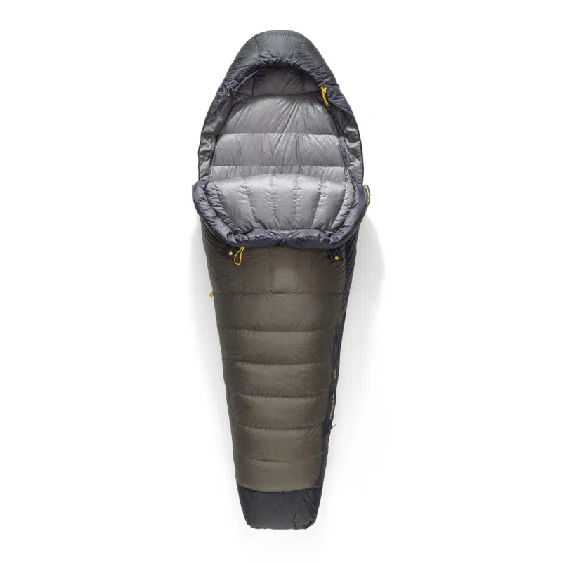 El saco de dormir Pluma Sea To Summit Spark Pro -9 C es un saco de dormir estilo momia gris y negro que presenta un interior aislado con un acabado elegante y una capucha cerrada, sobre un fondo blanco. Incluye cordones amarillos en la parte superior para facilitar los ajustes.