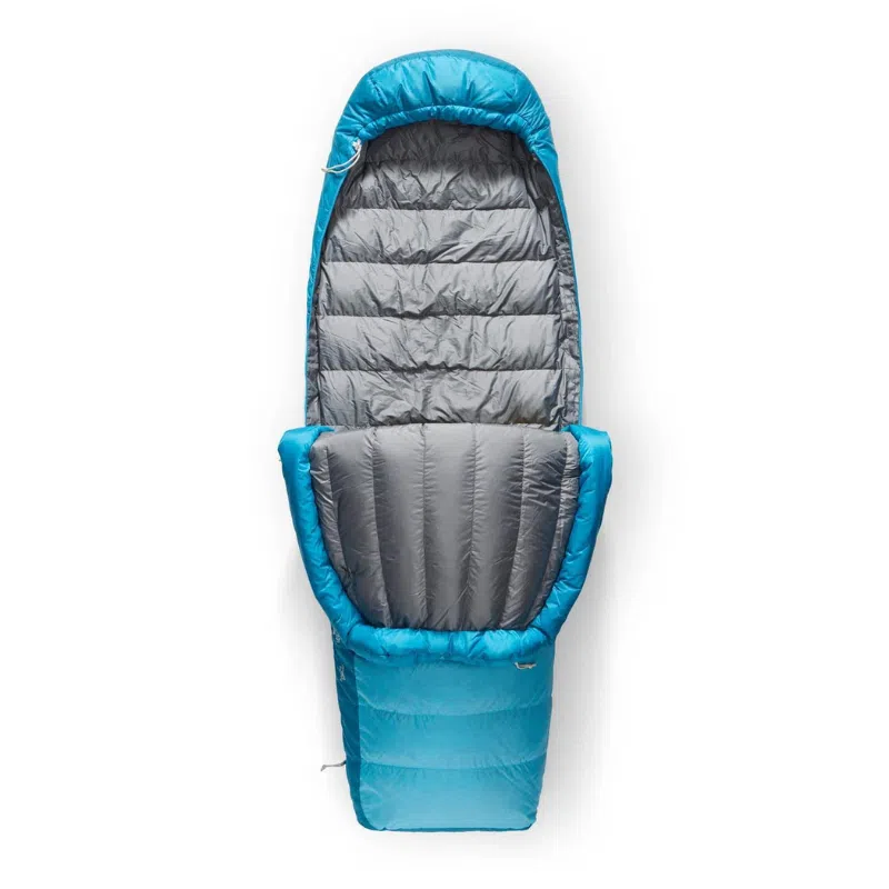 El saco de dormir Sea to Summit Trek -9°C en azul y gris es ideal para acampar en climas fríos. Cuando está completamente abierto, ofrece un interior espacioso con secciones acolchadas diseñadas para brindar calidez y comodidad, y se completa con una capucha para una cobertura adicional.