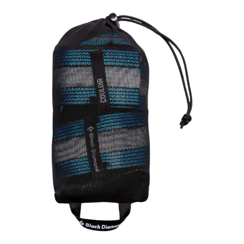 Un Arnés Black Diamond Couloir compacto en Ultra Blue/Black, con acolchado y correas visibles, viene empaquetado en una bolsa de almacenamiento de malla negra con cordón y correa de marca.