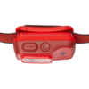 Una linterna frontal roja Black Diamond con una correa de tela y varios controles en el lateral. Esta linterna frontal recargable cuenta con un botón de encendido prominente y un interruptor texturizado, probablemente para ajustar el brillo o los ajustes de modo. La parte frontal tiene una lente transparente para el LED.