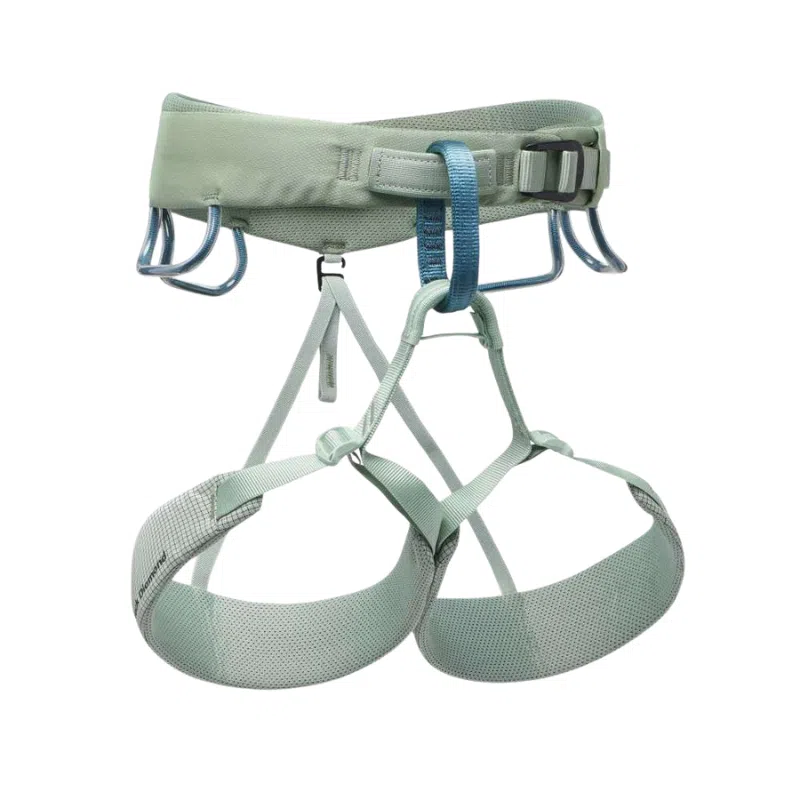 El Arnés Black Diamond Momentum Mujer es un arnés de escalada de color verde claro, equipado con correas ajustables, hebillas metálicas y cuatro portamateriales. Cuenta con perneras acolchadas para mayor seguridad y comodidad durante las actividades de escalada y se presenta sobre un fondo blanco.
