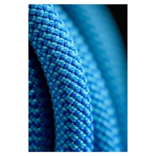 Primer plano de bobinas de cuerda azul Cuerda Black Diamond de 9,9 mm, tejidas firmemente, que resaltan la intrincada textura y el patrón. Las vibrantes fibras azules crean un diseño trenzado que se destaca sobre un fondo oscuro.